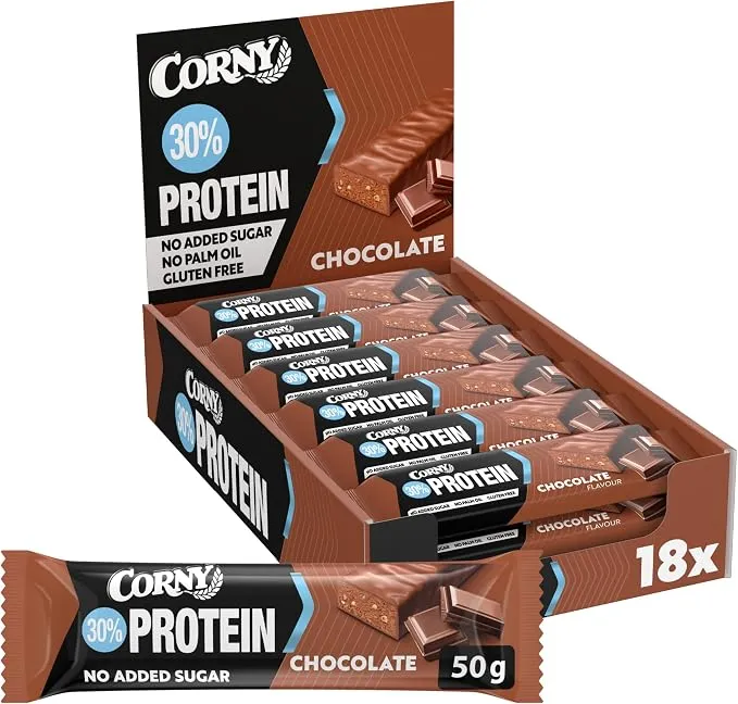 Une boîte ouverte de 18 barres protéinées Corny Protein au chocolat, avec une barre individuelle déballée au premier plan, montrant sa texture intérieure croustillante.