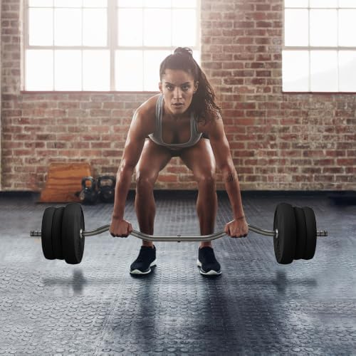 Une femme musclée en tenue de sport, les pieds écartés, tenant la barre coudée chargée de disques et se penchant en avant, prête à effectuer un mouvement de soulevé de terre ou de rowing.