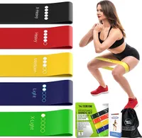 Un ensemble de cinq mini-bandes de résistance TechStone de couleurs différentes (noir, rouge, jaune, bleu, vert) avec leurs niveaux de résistance indiqués. À droite, une femme effectue un squat avec une bande jaune autour des cuisses. En bas, l'emballage du produit, un dépliant d'instructions et un sac de transport noir sont visibles.