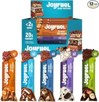 Un coffret de barres protéinées Joyfuel, avec une boîte de 12 barres et cinq barres individuelles de différentes saveurs (cacahuète, noix de coco, cookie dough, cookie cream, noisette) coupées pour montrer leur intérieur.