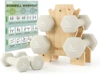 Un ensemble d'haltères PhysKcal de 1, 2 et 3 kg de couleur beige, rangés sur un support en bambou. Deux haltères de 1 kg sont posés devant le support. Une affiche d'exercices est visible en arrière-plan.