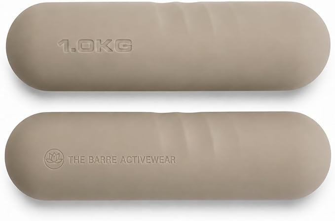 Deux haltères de forme ovale et de couleur beige clair, posées à plat sur un fond blanc. L'haltère supérieure affiche l'inscription "1.0KG" en relief, tandis que l'haltère inférieure porte le logo lotus et le texte "THE BARRE ACTIVEWEAR" en relief.